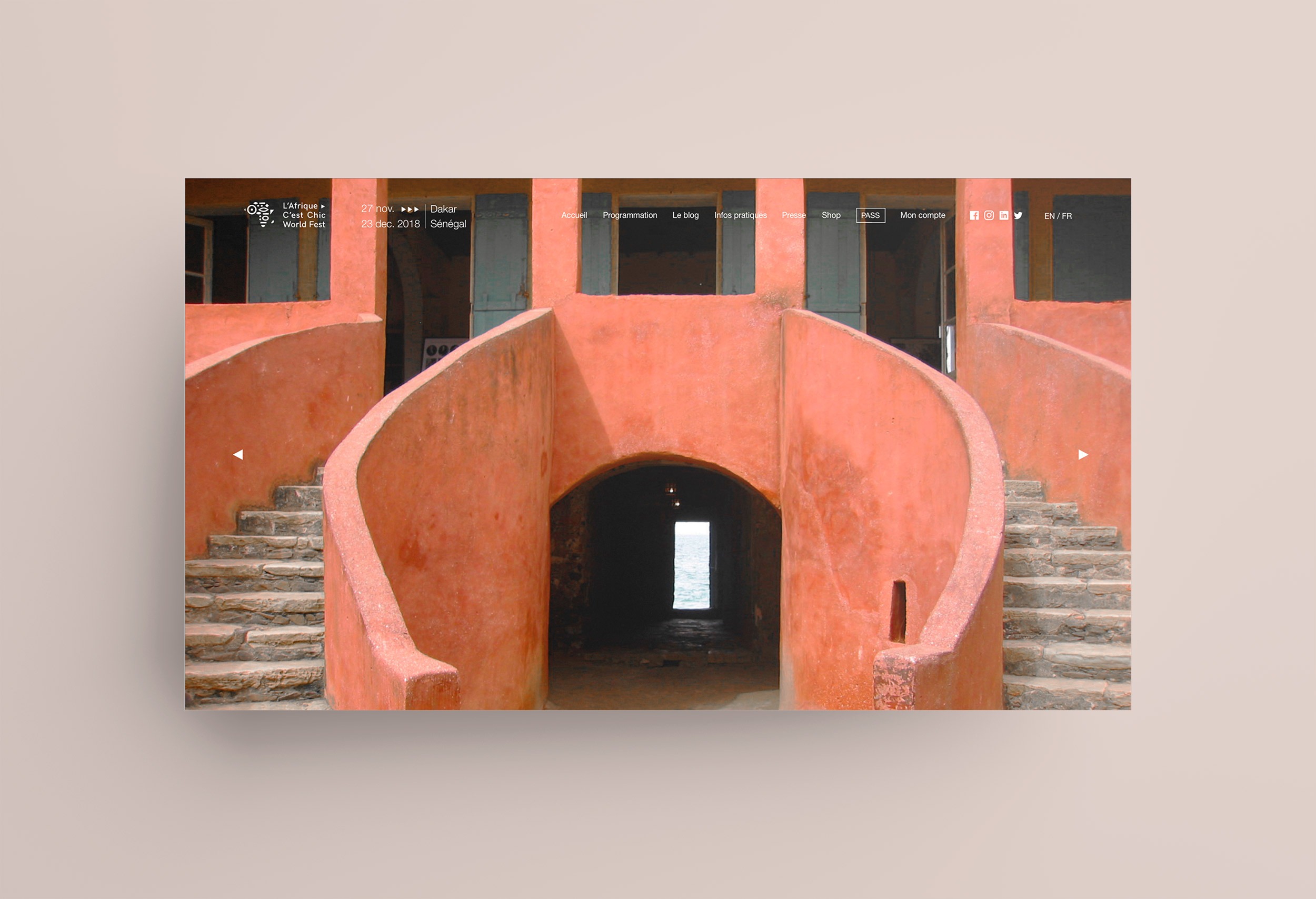 Page d'accueil du site de l'afrique c'est chic. On y voit le header du site en blanc, le fond est une image présentant un bâtiment colorés avec des escaliers