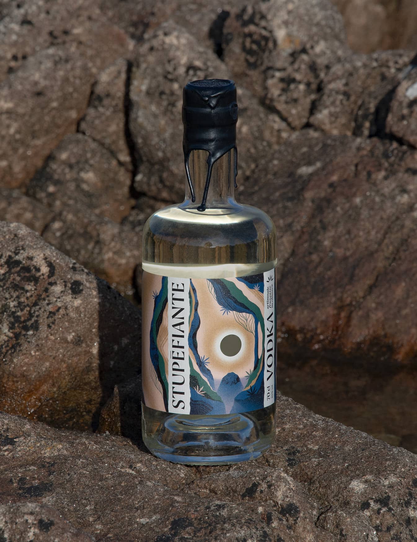 Bouteille de vodka Stupéfiante sur des rochers au bord de la mer